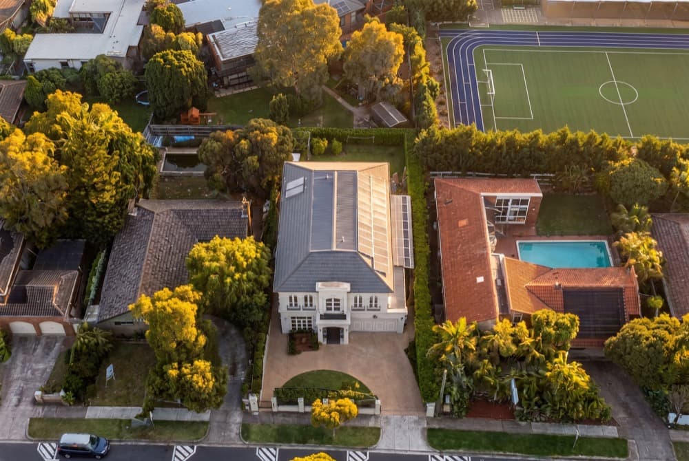 A golden hour aerial of a two storey house, the opening frame of a generated listing film